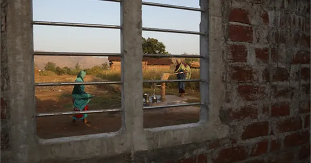 A rural village scene viewed through a window, evoking a single setting rendered whole.